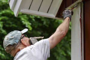 male painting the exterior of his house in ideal outdoor painting temperature